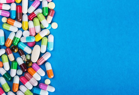 many scattered Colorful pills on blue backgroundの写真素材