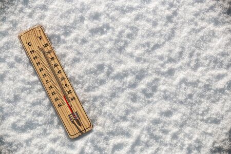 Wooden Thermometer in the snow with freezing temperatures