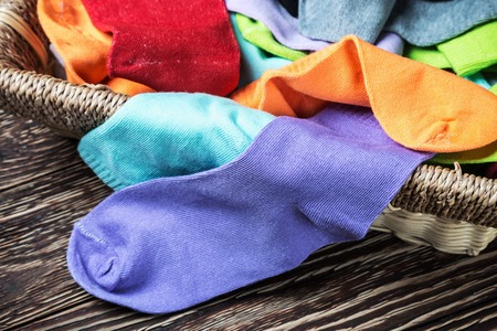 different color textile socks in the basket on the floorの写真素材