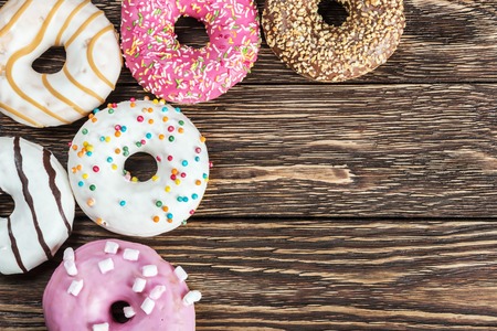 Assorted glazed donuts on a wooden tableの写真素材
