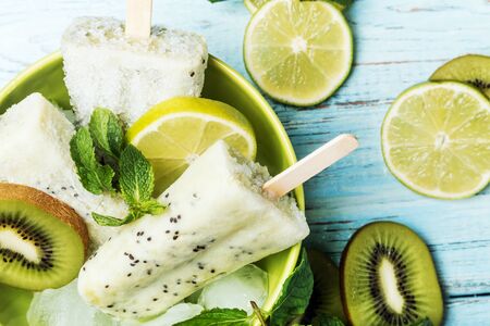 Fruit ice cream on a stick of kiwi and lime with mintの写真素材