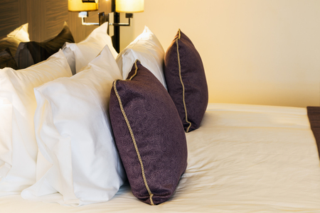 Cushions and dressed bed linen on the bed in the hotelの写真素材