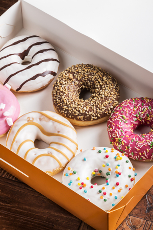 fresh assorted filled donuts in a box on the tableの写真素材