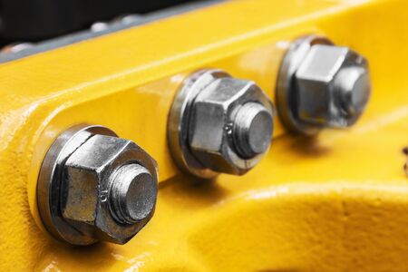 bolt and nut spun on the tractor or other construction equipment. focus on the nut of the foregroundの写真素材