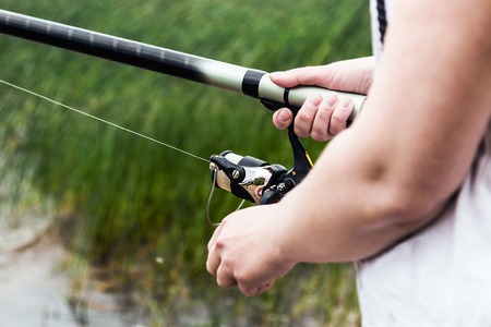 hand holding the rod and reel. Fishing accessoriesの写真素材