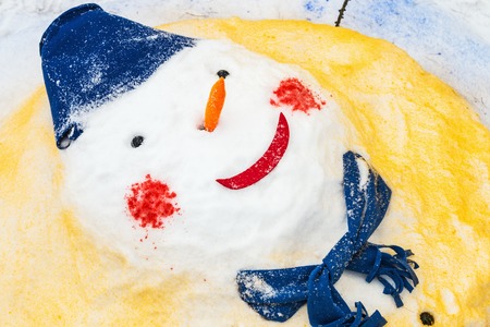 Snowman with a red nose stands in the Park in the snow. Winter fun and games in the fresh air. Funny snowmanの写真素材