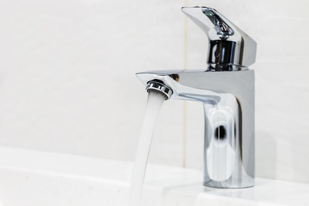 water faucet in the bathroom or toilet. water flows from the tapの写真素材
