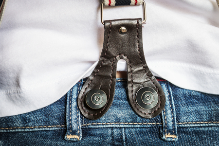 suspenders with big buttons on jeans on female body. clothing detailsの写真素材
