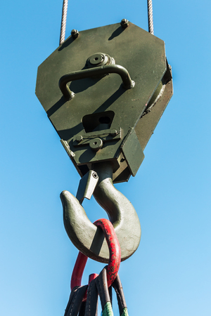 hook of a crane lifts a load on the background of blue skyの写真素材
