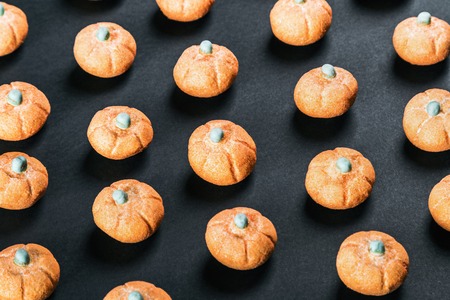 marshmallows in the shape of a pumpkin for the holiday Halloween on a black background.