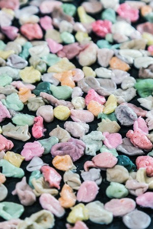 chewed chewing gum of different colors on a black backgroundの写真素材