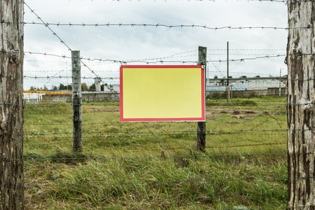 barbed wire stretched on the fence. information Plate for your text