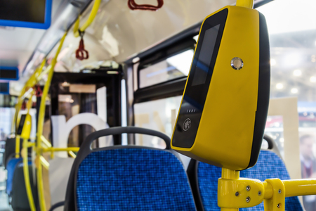 modern and comfortable City vehicle bus salon with empty passenger seats. Focus on yellow validatorの写真素材
