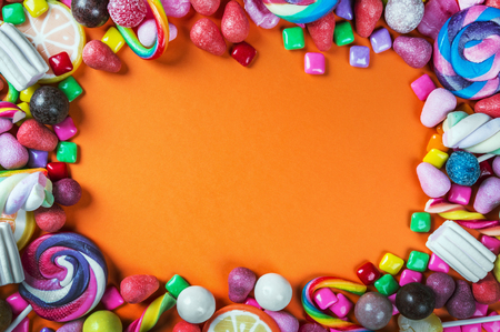 sweets are different on a black background, candy, gum, candy on a orange backgroundの写真素材