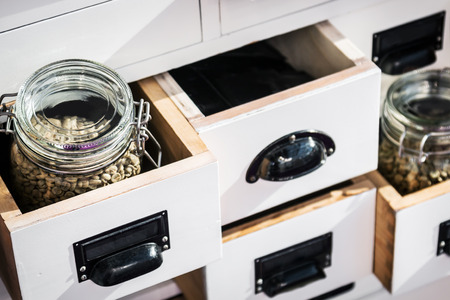 wooden chest with an assortment of different types of coffee. focus on the glass jar in the corner...