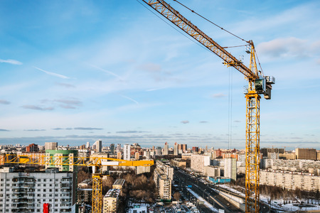 tower construction crane on the background of construction and the big cityの写真素材