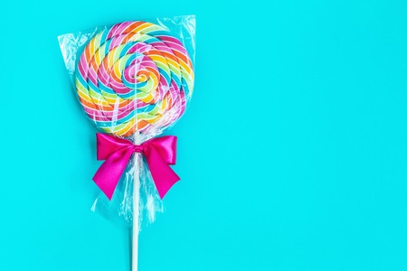 striped spiral multicolor Lollipop on blue background close upの写真素材