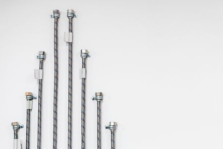 Flexible hose for water connection and nut on a light backgroundの写真素材