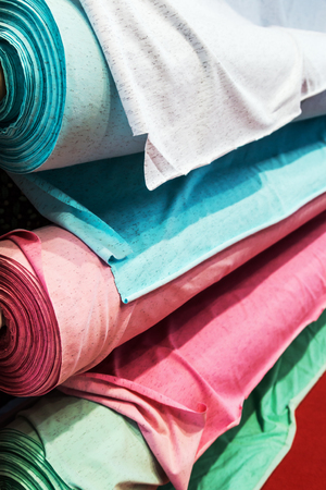 different color textile fabrics in rolls at the factory, shop windowの写真素材