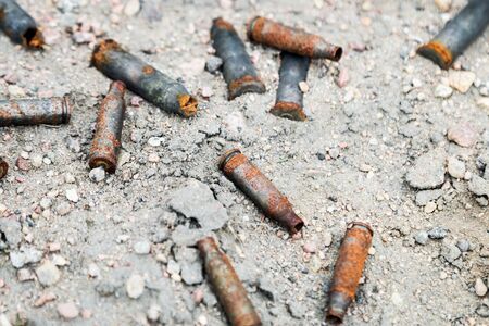 lots of old rusty gun casings on the ground.の写真素材