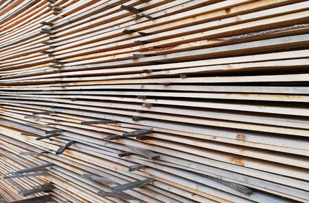 background of sawn boards in a stack. lumber at a sawmill or building materials store