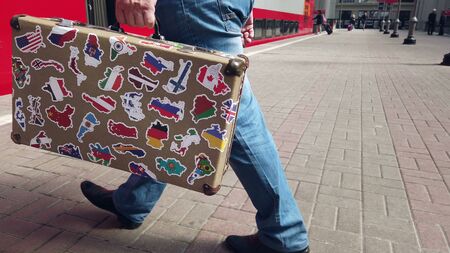 Moscow,Russia - August 8, 2019: suitcase with stickers from around the world stands on the platform of Kievsky railway station in Moscow. In the background, the train arriving at the stationのeditorial素材