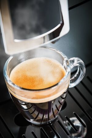 coffee beans are prepared in the coffee machine and poured into a glass Cupの写真素材