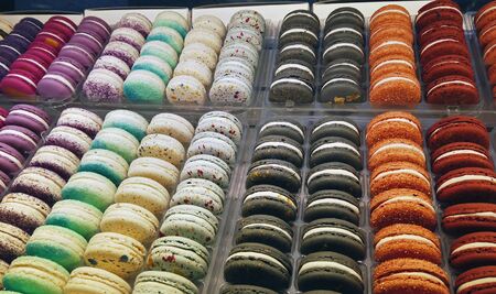 macaroon cakes of different colors on the counter in a candy store or shopの写真素材
