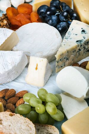 assorted cheeses, soft, hard, rennet and brine with fruits, nuts and dried fruitsの写真素材