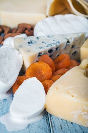 assorted cheeses, soft, hard, rennet and brine with fruits, nuts and dried fruitsの写真素材