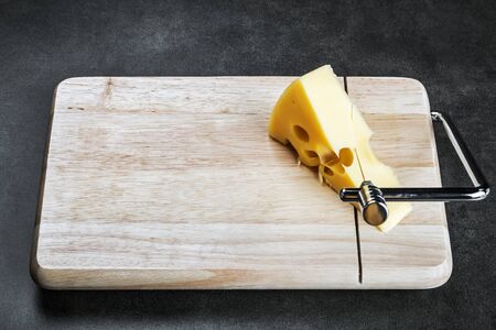 Maasdam cheese is cut on a special Board for cutting cheeseの写真素材