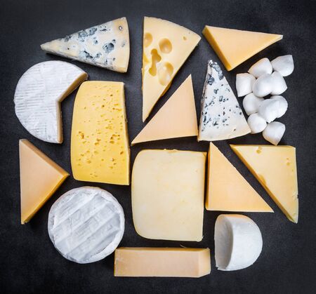 assorted cheeses, soft, hard, rennet and brine on a black backgroundの写真素材