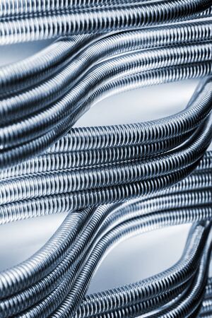 background of Corrugated stainless metal tubes for water supply sanitary equipment. Toned imageの写真素材