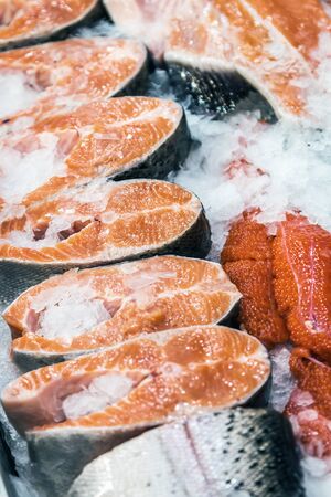 salmon steaks lie on crushed ice in a fish shop window or in a marketの写真素材