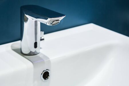 the water tap is mounted on the sink in the toilet or bathroom. The contrast of colorsの写真素材