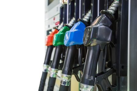Pump nozzles at the gas station isolated on white background. Shallow depth of field with focus on nozzle redの写真素材