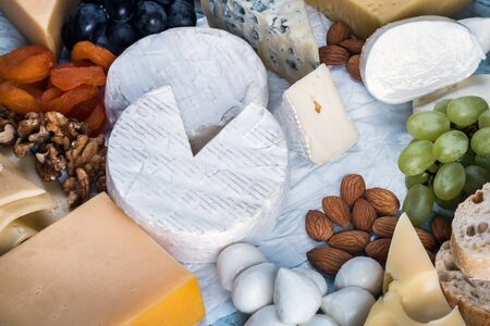 assorted cheeses, soft, hard, rennet and brine with fruits, nuts and dried fruitsの写真素材
