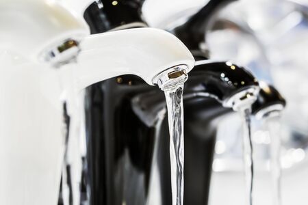 taps with running water are on the shop window. The contrast of black and whiteの写真素材