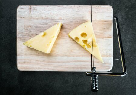 Maasdam cheese is cut on a special Board for cutting cheeseの写真素材