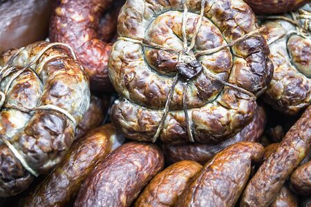 different sausages and smoked products on the store counter or in productionの写真素材