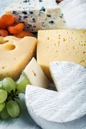 different varieties and types of cheese with fruit, nuts and baguetteの写真素材