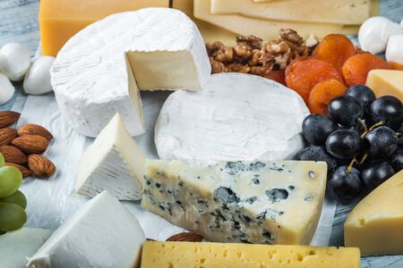 different varieties and types of cheese with fruit, nuts and baguetteの写真素材
