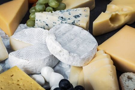 different varieties and types of cheese with fruit, nuts and baguetteの写真素材