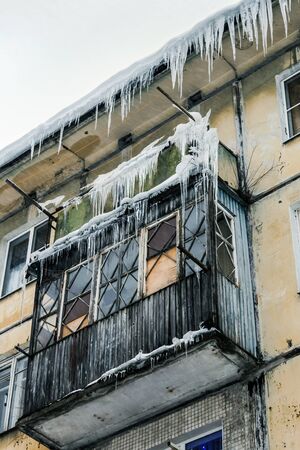 roof and balconies of the house in the snow and icicles after the snowfallの写真素材