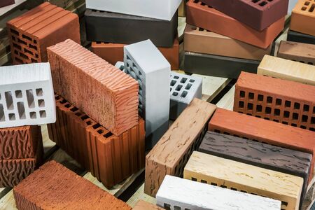 clinker, silicate, ceramic and other types of bricks of different colors. The background is of a...