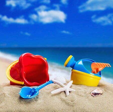 childrens toys on the sand on the background of the ocean shoreの写真素材