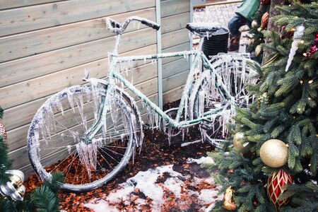 old Bicycle in the yard of the house in icicles and snow from the first frostの写真素材