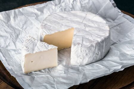 soft brie cheese is on the cutting Board on the tableの写真素材
