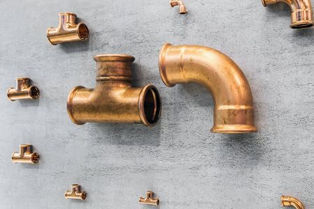 samples of copper pipes and fittings. Copper pipes, pipes and various parts on the wallの写真素材