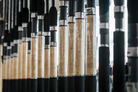 different rods and spinning rods for fishing on the counter in the store. Shallow depth of fieldの写真素材
